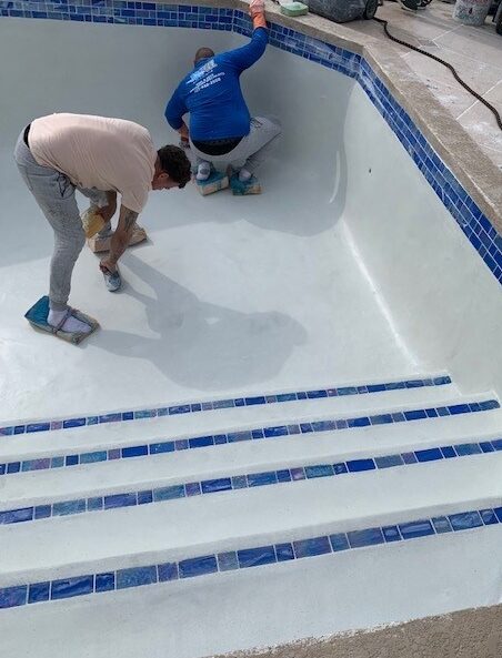 workers resurfacing pool