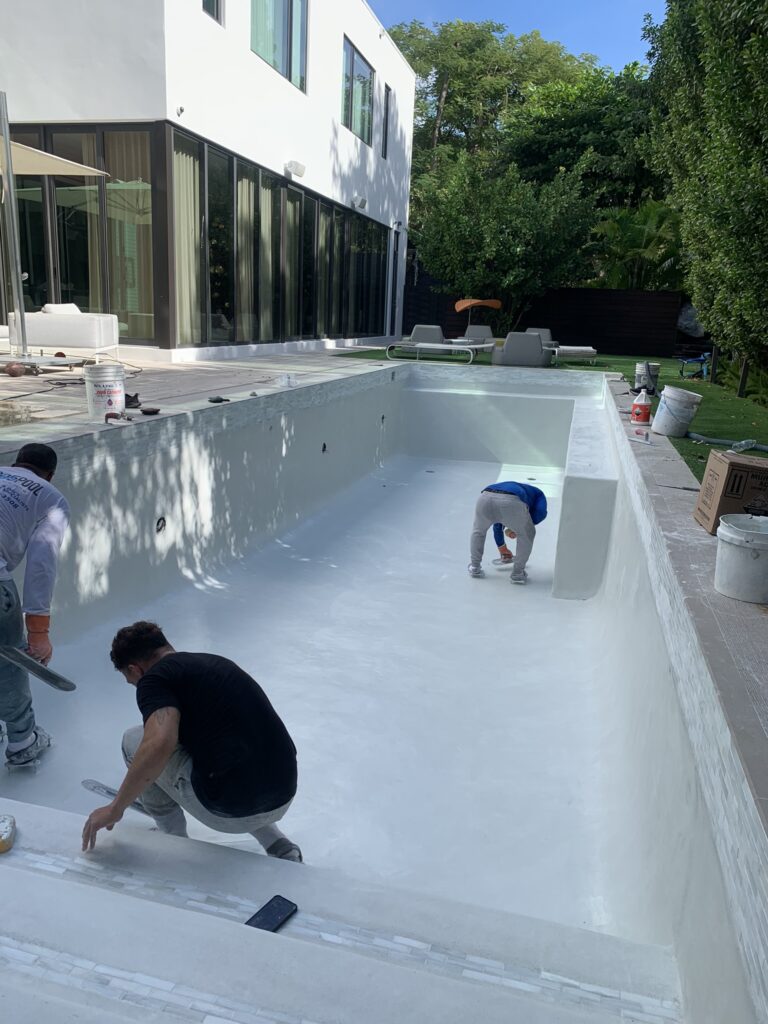 Guys-working-in-empty-Pool-Resurfacing-in-Coral-Gables-FL