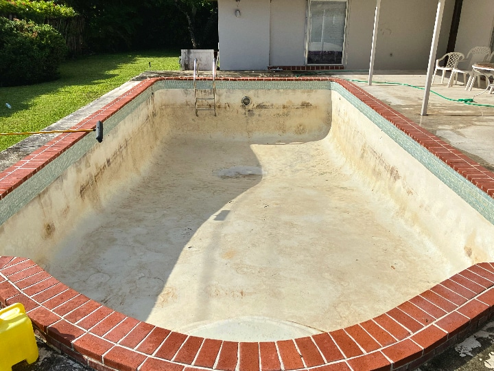 empty pool with algae in the preparation phase of pool resurfacing project